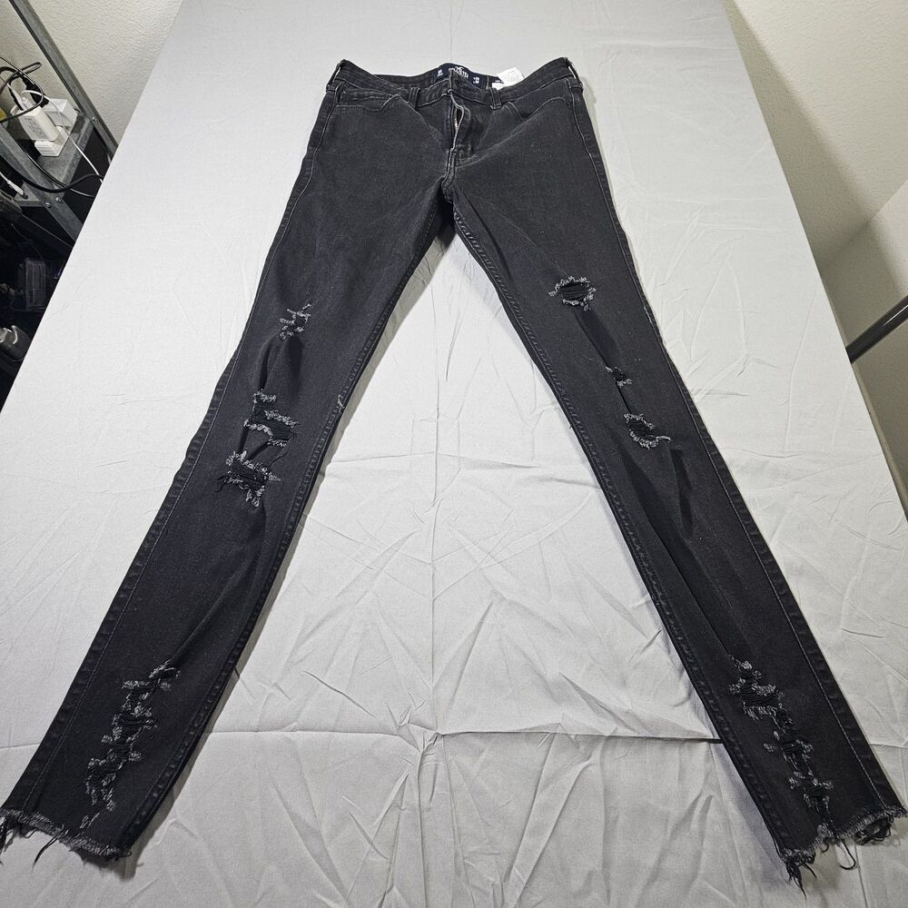 Hollister distressed black skinny jeans feature shredded rips along the front...